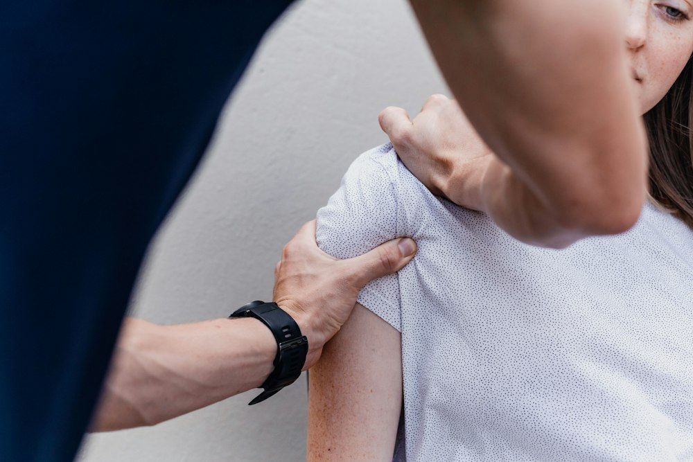 Therapist guiding a patient through a shoulder and arm exercise
